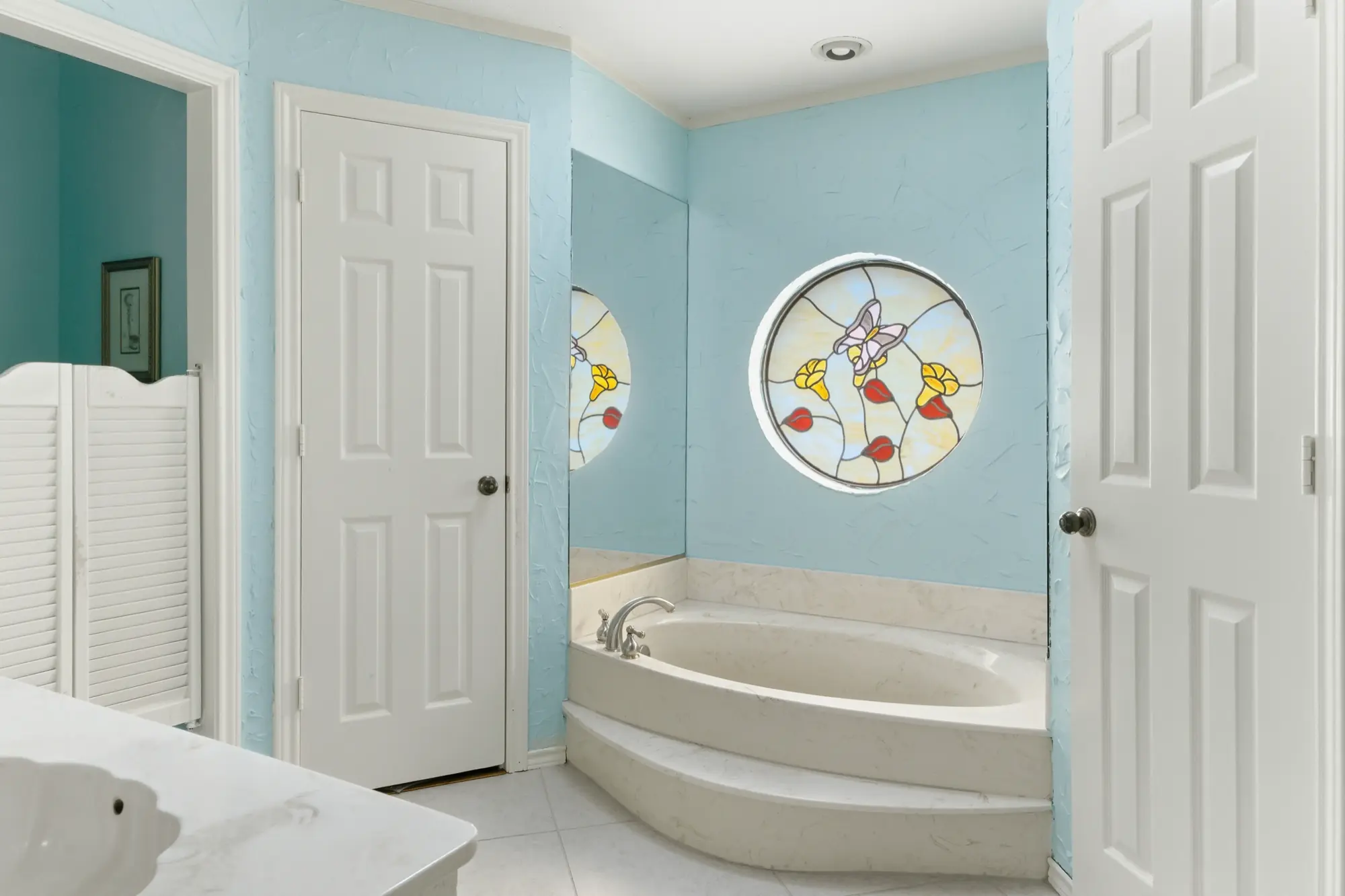 Primary bathroom with soaking tub and stained glass